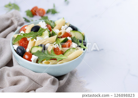 Mediterranean Pasta Salad in bowl with Fresh Vegetables and Herbs on green background Mediterranean Pasta Salad in bowl with Fresh Vegetables and Herbs on green background 126898823