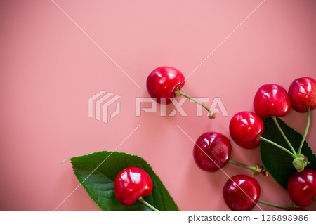 Ripe red cherries on pink background from above Ripe red cherries on pink background from above 126898986