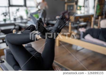 A detailed closeup of a foot work and core exercise on a Balanced Body Reformer machine illuminated by sunlight A detailed closeup of a foot work and core exercise on a Balanced Body Reformer machine illuminated by sunlight 126899133