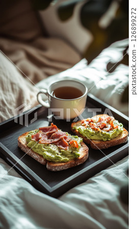 Savor the morning with colorful toasts topped with fresh ingredients and crispy bacon, paired with a warm cup of coffee, all set on a bed tray in a tranquil space 126899272