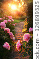 A serene path winds through a lush garden filled with soft pink peonies as warm sunlight filters through the trees, creating a peaceful atmosphere during golden hour 126899325