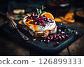 Delicious breakfast features toasted bread topped with creamy yogurt, fresh pomegranate seeds, and vibrant orange slices, perfect for an energizing start to the day 126899333