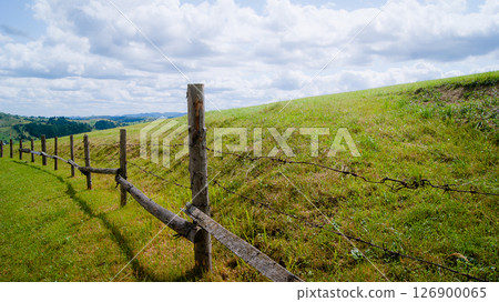 Wooden fence with barbed wire in the mountains 126900065