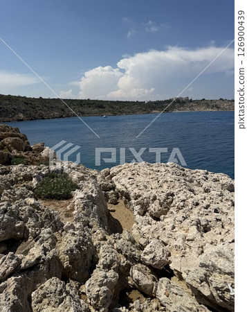 Picturesque beach, waves crashing on the sandy shore. Sea waves beat against the rocks. Cyprus Island, Mediterranean Sea. 126900439