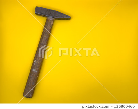 Rusty old hammer with wooden handle on yellow background. Flat lay. Top view, copy space. Rusty old hammer with wooden handle on yellow background. Flat lay. Top view, copy space. 126900460