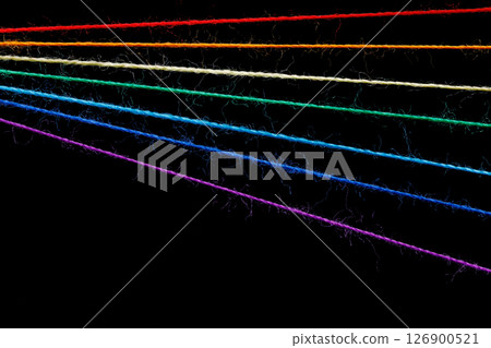 multicolored sewing threads in the form of a rainbow on a black background multicolored sewing threads in the form of a rainbow on a black background 126900521