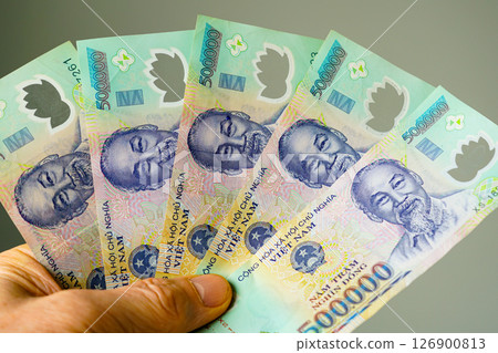 Vietnamese Dong Currency, Hand Holding 500,000 VND Banknotes Featuring Portrait of Ho Chi Minh Vietnamese Dong Currency, Hand Holding 500,000 VND Banknotes Featuring Portrait of Ho Chi Minh 126900813