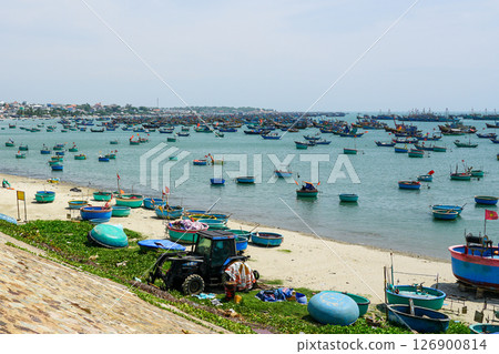 Hundreds of colorful traditional fishing boats anchored near a sandy beach in a Vietnamese village 126900814