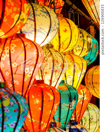 Bright Vietnamese Silk Lanterns Hanging in Rows, Glowing with Warm Light and Rich Patterns Bright Vietnamese Silk Lanterns Hanging in Rows, Glowing with Warm Light and Rich Patterns 126900835