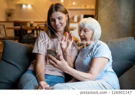 Volunteer and senior woman watching something on the phone 126901147