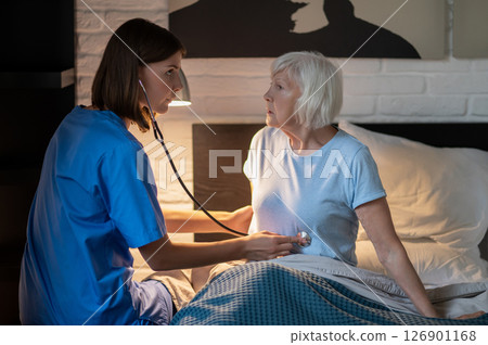 Doctor examining elderly patient and looking concentrated 126901168