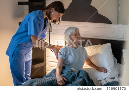 Doctor examining elderly patient and looking concentrated 126901170