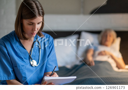 Doctor writing a prescription to an elderly female patient Doctor writing a prescription to an elderly female patient 126901173