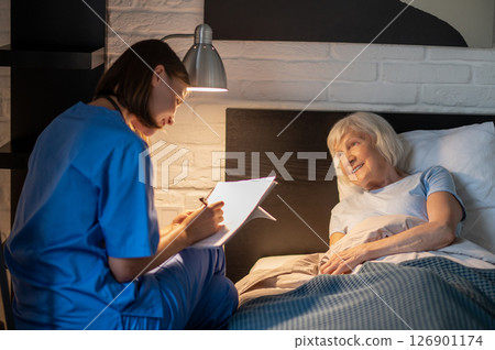 Doctor writing a prescription to an elderly female patient Doctor writing a prescription to an elderly female patient 126901174