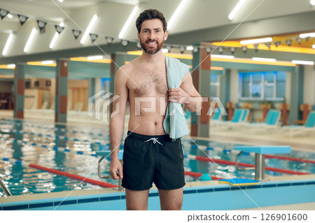 Confident caucasian athletic man with a towel in the swimming pool Confident caucasian athletic man with a towel in the swimming pool 126901600
