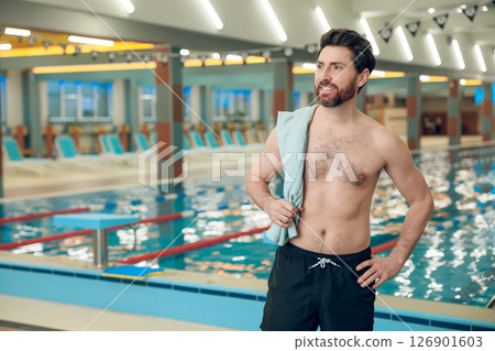 Confident caucasian athletic man with a towel in the swimming pool 126901603