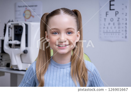 Smiling cute girl sitting in the ophthalmologist office and looking contented 126901667