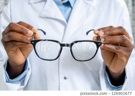 Close up of a doctors hands holding eyeglasses 126901677