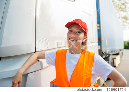 Portrait young adult happy smiling woman heavy truck driver modern cargo vehicle cabin background. Female person girl professional job career working driving freight engine lorry. Logistics industry Portrait young adult happy smiling woman heavy truck driver modern cargo vehicle cabin background. Female person girl professional job career working driving freight engine lorry. Logistics industry 126901734