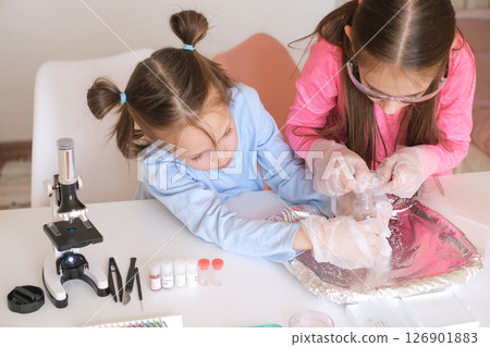 Homeschooling. The concept of science and education. Little girls are experimenting with test tubes and liquids. Homeschooling. The concept of science and education. Little girls are experimenting with test tubes and liquids. 126901883
