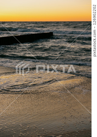 Ocean with waves, sunset sky is orange. water is choppy and waves are crashing on shore. Ocean with waves, sunset sky is orange. water is choppy and waves are crashing on shore. 126902202