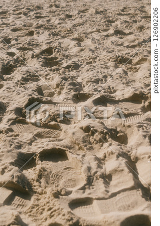 chain of footprints in the sand. The footprints of human shoes are arranged in row and very close. chain of footprints in the sand. The footprints of human shoes are arranged in row and very close. 126902206
