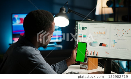 Financial manager doing accounting work on pc with chroma key screen, examining expenses for legal analysis at home setup. African american advisor working on reducing monthly costs. Camera B. Financial manager doing accounting work on pc with chroma key screen, examining expenses for legal analysis at home setup. African american advisor working on reducing monthly costs. Camera B. 126902719