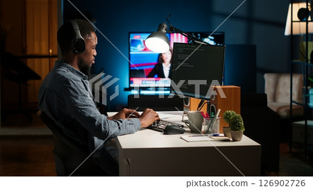 Young programmer engineer writing binary code data on terminal window, doing freelance work at home setup. Software developer working on troubleshooting with programming language. Camera B. Young programmer engineer writing binary code data on terminal window, doing freelance work at home setup. Software developer working on troubleshooting with programming language. Camera B. 126902726