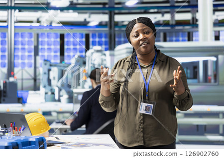 Black woman inspector explaining the new photovoltaics production, obtaining cheaper eco friendly energy. Female manager discussing about alternative energy for business development. 126902760