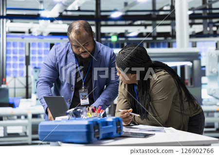 Black industry engineers team working together on solar panel systems during a production inspection, ensuring engineering accuracy, quality control and factory operations efficiency. Black industry engineers team working together on solar panel systems during a production inspection, ensuring engineering accuracy, quality control and factory operations efficiency. 126902766