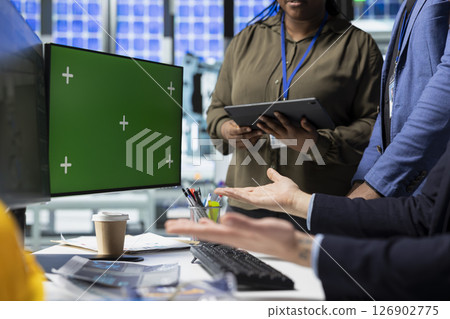 Coworkers brainstorming solutions with mockup display in solar plant, advancing industrial goals through collaboration and corporate responsibility. Team of engineers share insight. 126902775