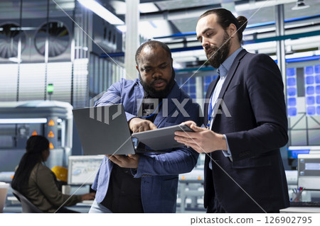 Coworkers team meeting in the factory to handle solar power production, showing teamwork in manufacturing process of photovoltaics. Green renewable energy system management in plant. Coworkers team meeting in the factory to handle solar power production, showing teamwork in manufacturing process of photovoltaics. Green renewable energy system management in plant. 126902795