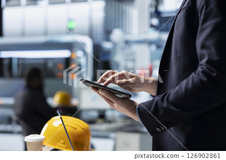 Operations director in a solar panel factory monitoring efficiency metrics and system outputs, combining leadership with real time quality inspection and strategic business development. 126902861