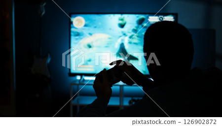 Guy spends time on television playing multiplayer web video games, setting his console into smart tv and having fun gaming at night. Player battling in shooter competition. Camera A. Guy spends time on television playing multiplayer web video games, setting his console into smart tv and having fun gaming at night. Player battling in shooter competition. Camera A. 126902872