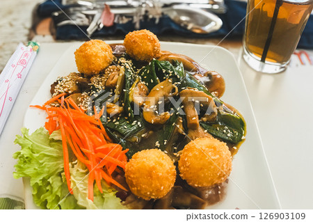 Fried fish balls in sweet and sour sauce with sesame seeds 126903109