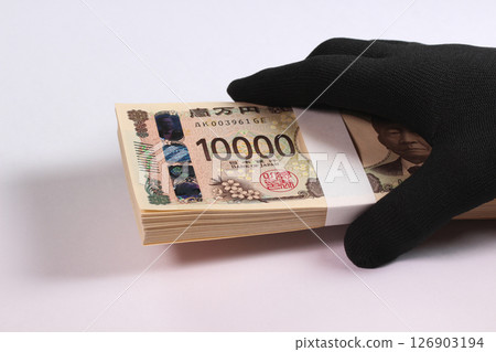 Holding a stack of bills in black gloves Holding a stack of bills in black gloves 126903194
