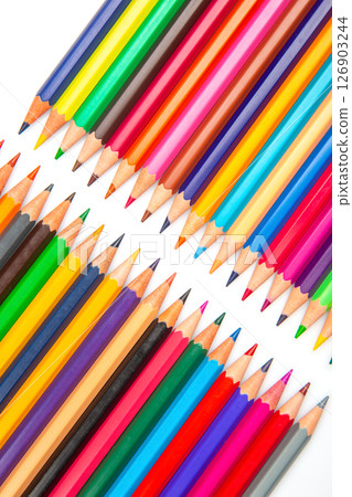 A vibrant row of sharpened colored pencils in various hues against a white background 126903244