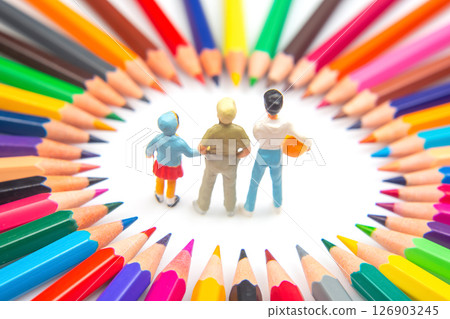 Three figurines are encircled by a spectrum of colored pencils, arranged in a starburst pattern, 126903245