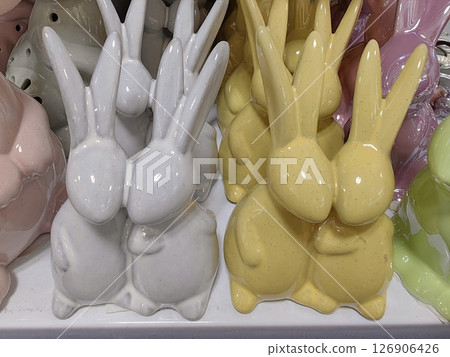 decorative ceramic bunnies in pastel colors displayed on store shelf during spring season. closeup. 126906426