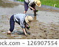 A rice terrace owner planting rice 126907554