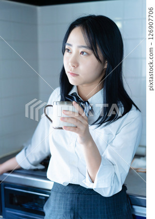 High school girl drinking coffee in the kitchen 126907706