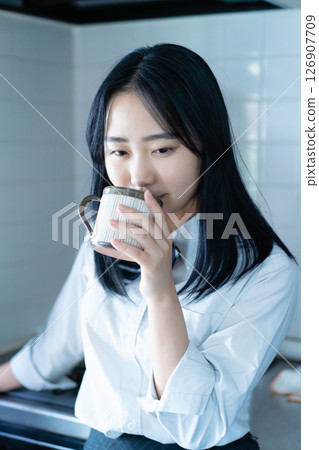 High school girl drinking coffee in the kitchen 126907709