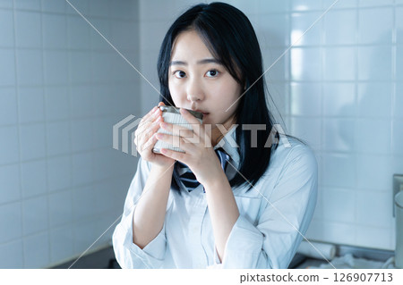 High school girl drinking coffee in the kitchen High school girl drinking coffee in the kitchen 126907713