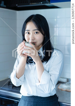 High school girl drinking coffee in the kitchen High school girl drinking coffee in the kitchen 126907714