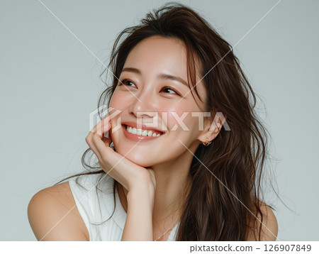 一位自然女性的肖像，用手托著臉頰微笑 126907849