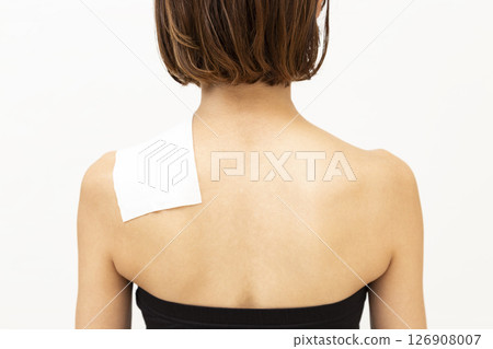 Back view of a woman with a compress on her shoulder Back view of a woman with a compress on her shoulder 126908007