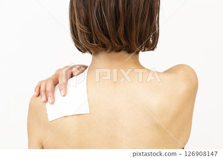 Back view of a woman with a compress on her shoulder Back view of a woman with a compress on her shoulder 126908147