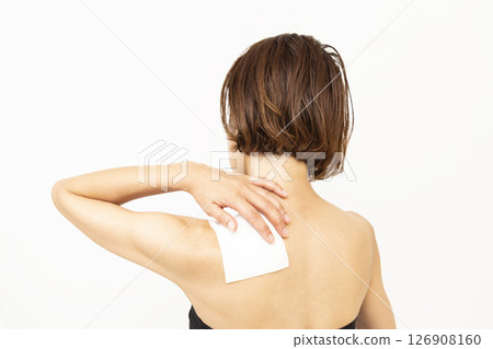 Back view of a woman with a compress on her shoulder 126908160