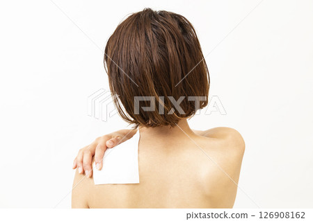 一位肩上敷有敷布的女士的後背 126908162