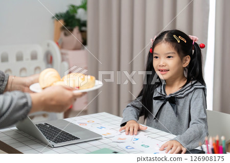 Joyful Learning Experience. Girl smiling while engaging in educational activities at home. Joyful Learning Experience. Girl smiling while engaging in educational activities at home. 126908175